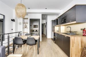 a kitchen and dining room with a table and chairs at 149 Suite Christophe - Superbe Appartement à Paris in Paris