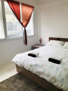 1 dormitorio con 1 cama grande y ventana en Homies.Bkk, en Bangkok