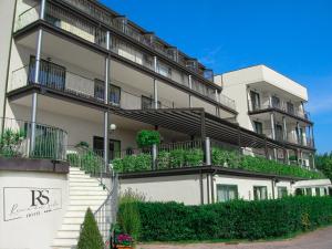 an apartment building with plants on the balconies at AHG Riva Del Sole Hotel in Moniga