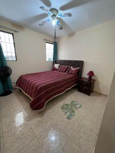 a bedroom with a bed and a ceiling fan at Comfortable and cute in Santo Domingo