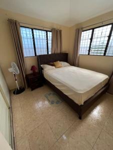 a bedroom with a bed and two large windows at Comfortable and cute in Santo Domingo