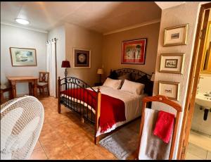 a bedroom with a bed and a table and chairs at OakTree Guest House in Sandton
