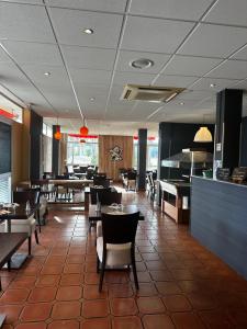 a restaurant with tables and chairs and a cafeteria at L'Aquitaine - Cahors Sud in LʼHospitalet