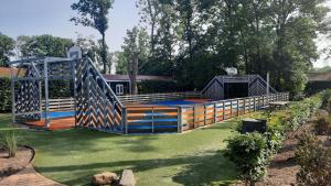 a wooden bridge in the middle of a yard at Das Holland Beachhouse, modern eingerichtet, in schöner Lage am Veluwemeer, inklusive Garten, Terrasse am Wasser, Parkplatz und WLAN in Hulshorst