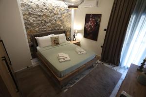a bedroom with a bed with two towels on it at LA Larissa Luxury Apartments Kreousa in Larisa