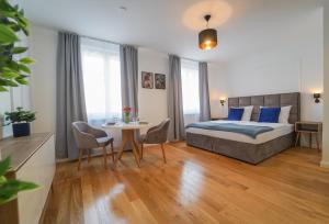 - une chambre avec un lit et une table avec des chaises dans l'établissement BelVie Residence, à Vienne