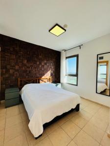a bedroom with a large bed and a brick wall at pisgat shoresh in Shoresh