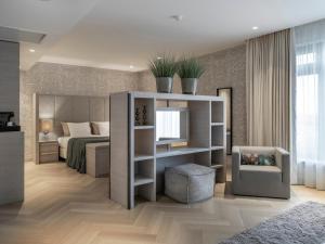 a bedroom with a bed with a mirror and a chair at Van Der Valk Hotel Zwolle in Zwolle