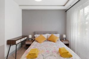 ロンドンにあるThe Pearl - Luxury 5* Home with Park Viewのベッドルーム1室(黄色いタオルが付いたベッド1台付)