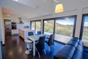 een woonkamer met een bank en een tafel met stoelen bij Catalunya Casas Modern Hilltop Haven with private pool 7km to beach in Castellet