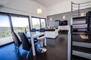 een woonkamer met een tafel en stoelen en een bank bij Catalunya Casas Modern Hilltop Haven with private pool 7km to beach in Castellet