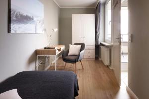 1 dormitorio con cama, escritorio y silla en Haus Uthlande 39, en Wyk auf Föhr
