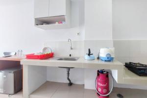 uma pequena cozinha com um lavatório e um balcão em Brand New and Nice Studio at Skyview Medan Apartment By Travelio em Sunggal