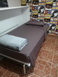 een bed in een kamer naast een muur bij La casa de Rei in Sardina