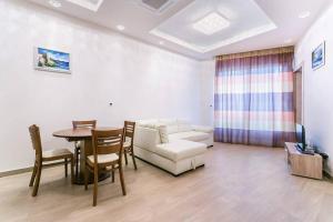 a living room with a white couch and a table at Stylish spacious apartment near the sea in Budva