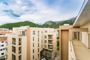 an apartment building with mountains in the background at Stylish spacious apartment near the sea in Budva