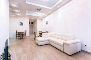 a living room with a white couch and a table at Stylish spacious apartment near the sea in Budva