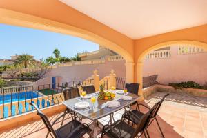 een patio met een tafel en stoelen op een balkon bij Villa Amanda - PlusHolidays in Calpe