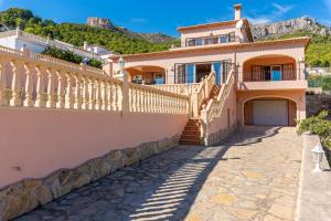 a villa with a staircase in front of a house at Villa Amanda - PlusHolidays in Calpe
