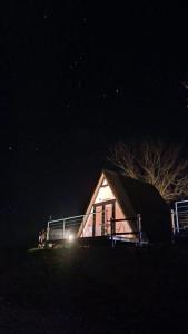 una pequeña casa por la noche con sus luces encendidas en Torretta Glamping & Relax, en Arola
