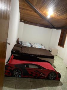 a bedroom with a bed with a toy car on the floor at Rancho dos Deuses in Guapé