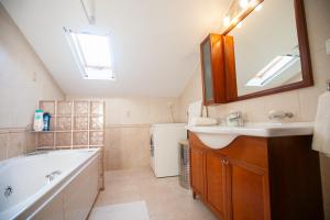 a bathroom with a sink and a tub and a mirror at Rodon Apartment with Great View, Sauna and Jacuzzi in Litochoro
