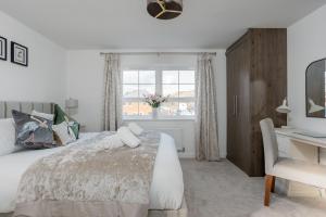 a bedroom with a bed and a desk and a window at Ballard House in Swanage