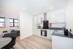 a kitchen and living room with a table and a couch at Studio Apartment in Liverpool City Centre in Liverpool