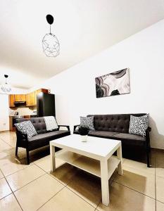 ein Wohnzimmer mit einem Sofa und einem Couchtisch in der Unterkunft Mackenzie 11 in Larnaka