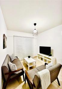 ein Wohnzimmer mit einem Sofa und einem TV in der Unterkunft Mackenzie 11 in Larnaka