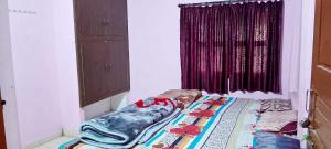 łóżko w pokoju z oknem w obiekcie Ram priya kunj Atithi Niketan w mieście Ayodhya