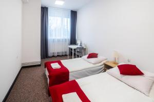 a hotel room with two beds with red accents at Pokoje gościnne OSiR in Zamość