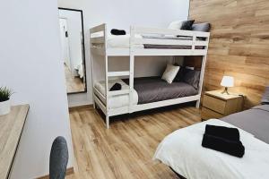 a bedroom with two bunk beds and a mirror at apartamento premium muy cerca ciudad Barcelona in Badalona