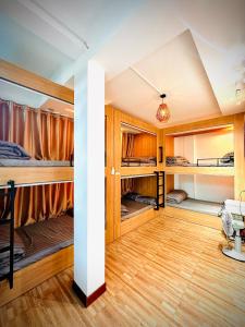 a room with multiple bunk beds and wooden floors at Ti Lau Homestay & Motorbikes in Ha Giang