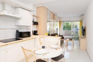 una cucina con tavolo e sedie in una stanza di COSY STUDIO - Résidence front de mer - Menton a Mentone