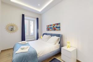 um quarto branco com uma cama azul e um espelho em Suite Gold-Stars FSHH em Nice