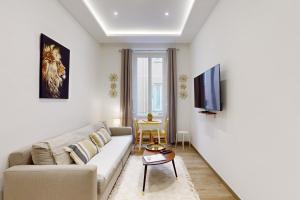 uma sala de estar com um sofá e uma televisão em Suite Gold-Stars FSHH em Nice