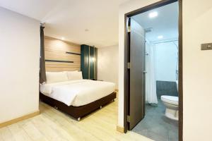 a bedroom with a bed and a bathroom with a toilet at City Park Hotel Bangkok Pratunam by PCL in Bangkok