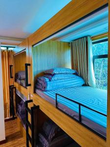 a bedroom with two bunk beds and a window at Ti Lau Homestay & Motorbikes in Ha Giang