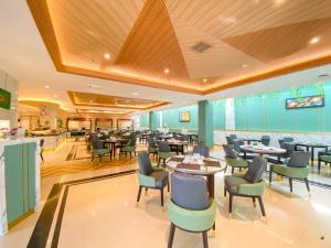 a restaurant with tables and chairs in a room at Luxury Malioboro Hotel in Yogyakarta