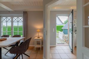 a kitchen and dining room with a table and chairs at Hüs Leen in Hedehusum