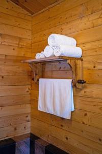 La salle de bains est pourvue de serviettes sur un mur en bois. dans l'établissement ama Stays & Trails Eden Farms , Goa, à Marmagao