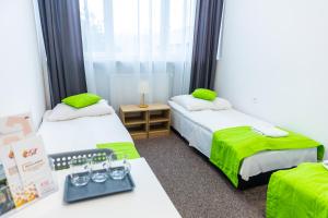 ザモシチにあるPokoje gościnne OSiRのベッド2台、体重計付きのデスクが備わる客室です。