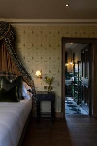 a bedroom with a bed and a table with a lamp at Kildrummy Inn in Kildrummy