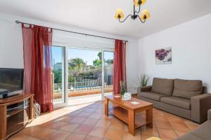a living room with a couch and a tv at Villa Amanda - PlusHolidays in Calpe