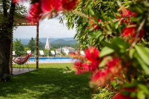 un patio con una silla y una piscina con flores en Ca L'Estamenya en Perafita