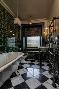 baño con 2 lavabos, bañera y ventana en Kildrummy Inn, en Kildrummy