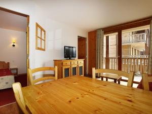 une salle à manger avec une table en bois et une télévision dans l'établissement A315- Appartement 3 pieces 6 personnes, à Orcières