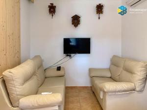 sala de estar con 2 sofás blancos y TV de pantalla plana en Cas rellotger country house en Llucmajor