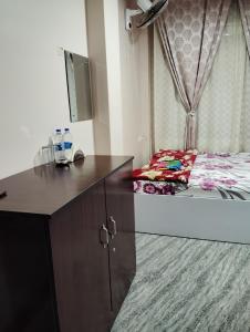 a bedroom with a desk and a bed with a dresser at Apurna Guest House Dawki in Dawki